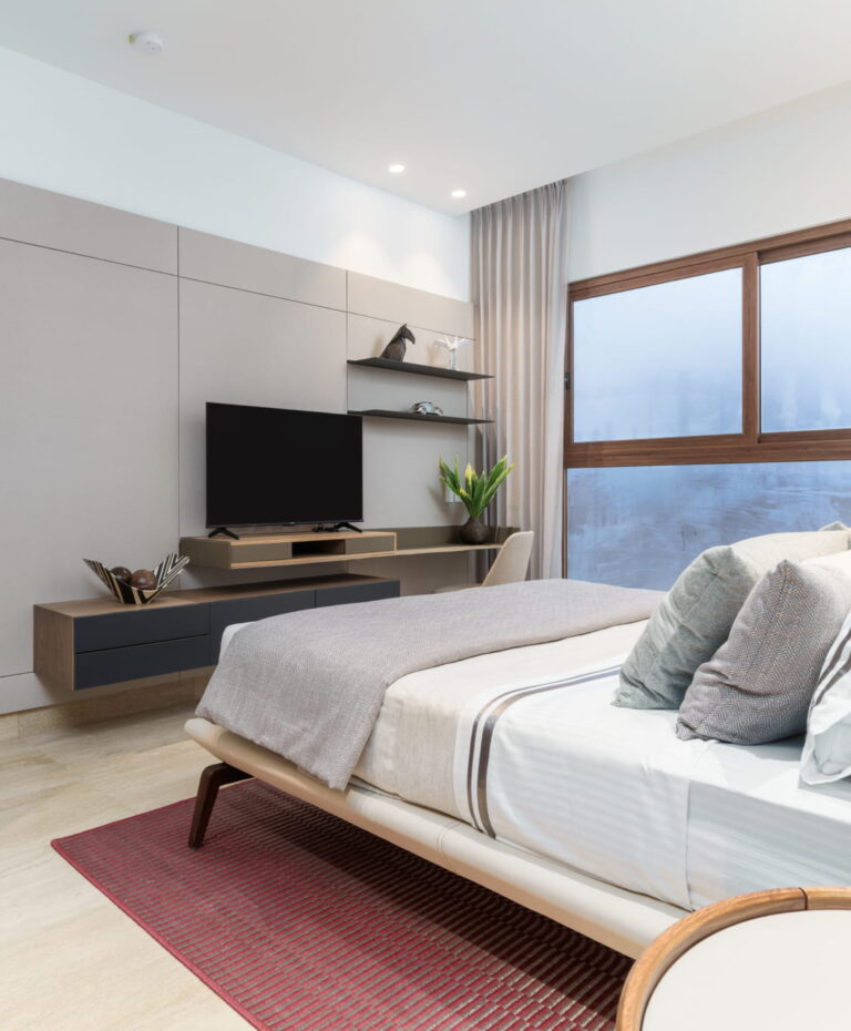 Dormitorio principal moderno con cama, TV, repisas decorativas y ventana amplia en The Woods Santa María.
